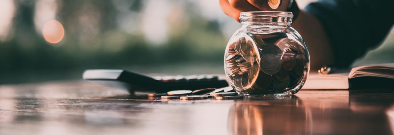 Man dropping a Canadian coin in a jar